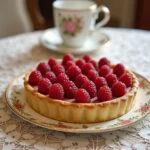 Elegant Bridgerton Regency Raspberry Tart with a golden crust and fresh raspberries, perfect for a regal dessert.