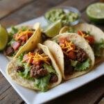 Final presentation of Better Call Saul Taco Plate with seasoned tacos and guacamole served on a rustic table.