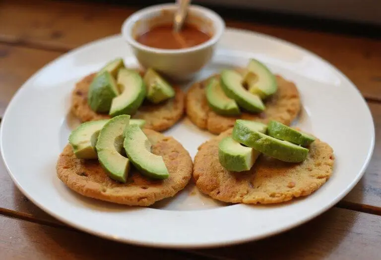 Serving Colombian Arepas on a plate, topped with fresh ingredients, exemplifying a delicious Colombian culinary experience.