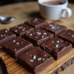 The finished Stranger Things Eleven’s Chocolate Bar cut into squares, beautifully presented, alongside a warm cup of cocoa for an inviting dessert experience.