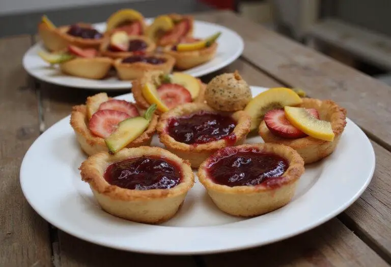 Delicious baked Crown Jam Tarts served on a rustic table, showcasing their vibrant jam filling and artistic presentation.