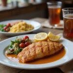 Finished True Blood Cajun Catfish served on a table, showcasing crispy fillet with sides, perfect for enjoying a delicious Cajun meal.