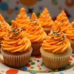 A stunning presentation of Charlie and the Chocolate Factory Oompa Loompa Orange Cupcakes, perfect for festive occasions, showcasing their colorful and playful design.