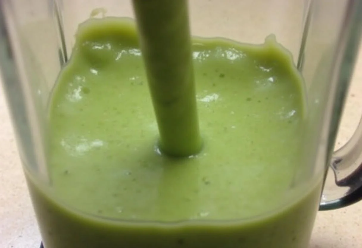 Pouring the delicious Dragon Ball Z Senzu Bean Smoothie into a glass, showcasing its vibrant green color and fresh ingredients.