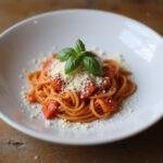 Final presentation of Easy A Emma Stone's Scarlet Letter Red Pepper Pasta with garnishes, showcasing its rich colors and appealing texture.