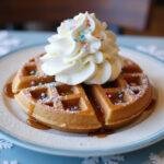 Deliciously served Frozen Olaf's Warm Hugs Waffles with whipped cream and sprinkles, creating a festive presentation.