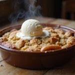 Delicious finished Hannibal Abigail Hobbs' Apple Crumble served warm with melting vanilla ice cream, perfect for dessert.