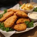 Delicious Marvel X-Men Wolverine's Claws Chicken Fingers presented on a platter with dipping sauce, showcasing their crispy texture.