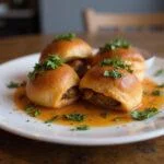 Delicious and visually appealing Riverdale Southside Serpents Spicy Sausage plant-based Rolls served with herbs and sauce, showcasing a tasty vegan dish.