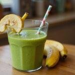 Final presentation of Shrek's Swamp Green Smoothie in a glass on a wooden table, highlighting its vibrant green color and decorative banana slice and straw.