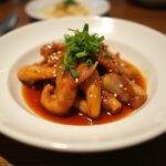 Final presentation of Squid Game Gganbu Gang-jeong Sweet Spicy Chicken, garnished with green onions and sesame seeds, served on a rustic wooden table.