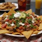 Delicious Dunder Mifflin Paper Plate Nachos ready to serve with colorful toppings, perfect for any party.