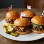 Final presentation of The Simpsons Krusty Burger Sliders plated with pickles, highlighting the appealing look of these mini burgers ready to be enjoyed.