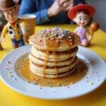 Delicious Toy Story Hamm's Piggy Bank Pancake Stack served on a breakfast table with syrup and playful decoration