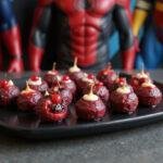 Close-up of Marvel Black Widow Berry Bites presented on a dark Marvel-themed tray, with colorful berries and glossy coating, set in a superhero-inspired kitchen environment, emphasizing a healthy, superhero snack vibe.