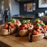 Close-up of Hawkeye's Bullseye Bruschetta arranged on a wooden platter, garnished with chopped herbs and balsamic reduction, with Marvel superhero decorations subtly visible in a kitchen setting.