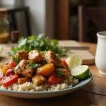 Close-up of Phil's Phantastic Fajita Bowls on a wooden table in a contemporary kitchen. The bowl features vibrant grilled chicken, sautéed peppers and onions, rice, and fresh herbs, styled in a realistic, appetizing way suitable for a Modern Family episode.