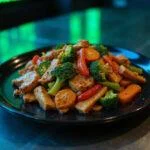 Close-up of Neo's Chosen One Chicken Stir-fry plated beautifully, showcasing the vivid vegetables and tender chicken coated in a glossy sauce. The presentation is set on a modern, high-tech kitchen counter with subtle digital motifs and cool lighting evoking the cyber environment of the Matrix universe.