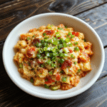 Colorful fusion fried rice served on a sleek white plate, vibrant vegetables, crispy bits, garnished with green onions and sesame seeds, styled for a lively anime or gaming theme, appealing and appetizing.