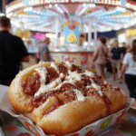 Colorful Dumbo Carnival Hot Dogs served on vibrant paper trays with bright condiments, topped with relish, ketchup, and mustard, presented in a festive carnival setting, with an array of classic carnival treats visible in the background, captured with lively and appetizing textures.
