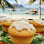 Colorful Moana Coconut Icing Cupcakes with fluffy white coconut-flavored frosting topped with toasted coconut flakes, arranged neatly on a vibrant tropical-themed plate, set against a bright background with subtle ocean-inspired accents, textures of soft cake and crunchy coconut create an inviting tropical vibe.