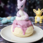 A vibrant pink and purple Pokémon Mewtwo Psychic Soufflé, elegantly risen in a crisp ramekin, topped with a delicate dusting of powdered sugar and edible glitter, set on a whimsical cosmic-themed plate with subtle glow effects, highlighting the airy and fluffy texture, styled with a Pokémon-themed backdrop for a magical ambiance.