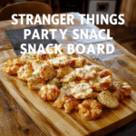 Vibrant Stranger Things inspired party snack board arranged on a rustic wooden board with neon Hawkins vibes. The board features an assortment of cheeses, cured meats, crisp crackers, berry clusters, veggie sticks, and themed dips, artfully grouped into color-coordinated sections. Textures range from creamy cheeses to crunchy pretzels and juicy fruit, finished with small decorative accessories and blue accents.